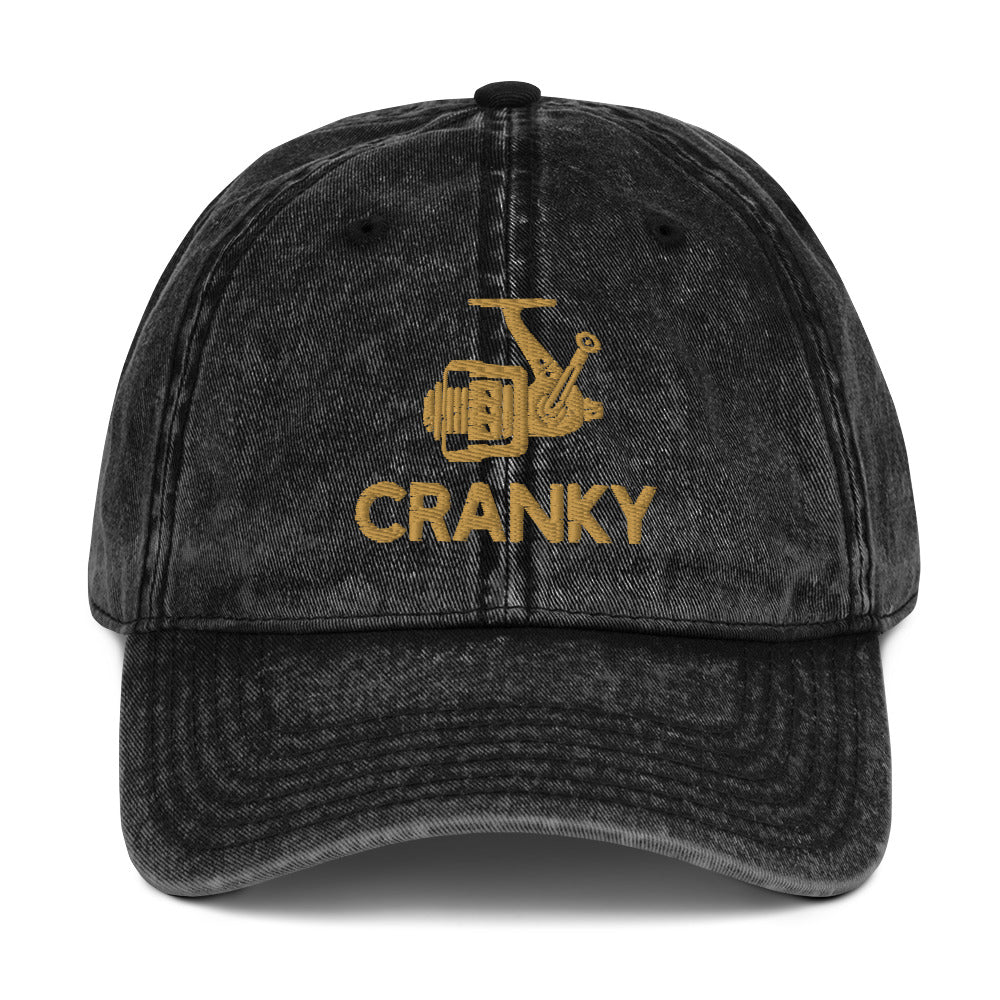 Front view of the black Cranky vintage dad hat featuring a distressed fishing reel design.